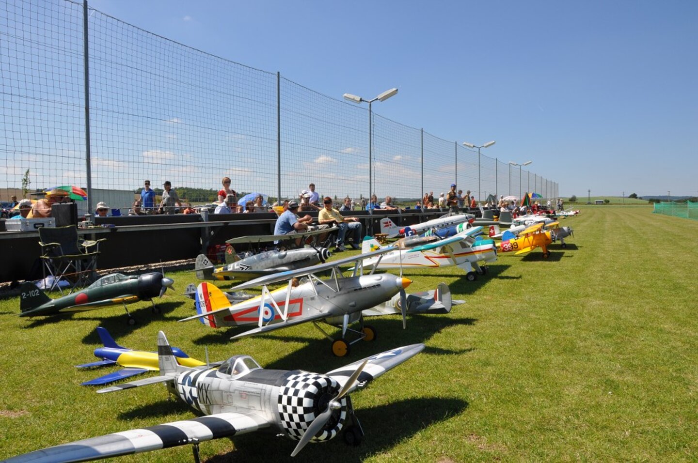 Řada RC modelů letadel podél oplocení dráhy